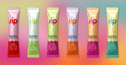 Six colorful 'Sip' electrolyte and vitamin sachets on a gradient background